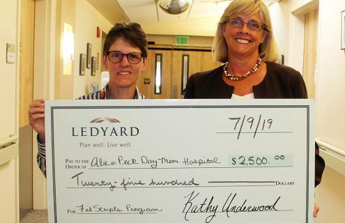 APD's President and CEO Sue Mooney, left, accepting the check from Ledyard’s President and CEO Kathy Underwood